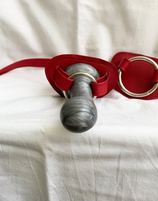 2 red leather hand strapon harness with a silver dildo