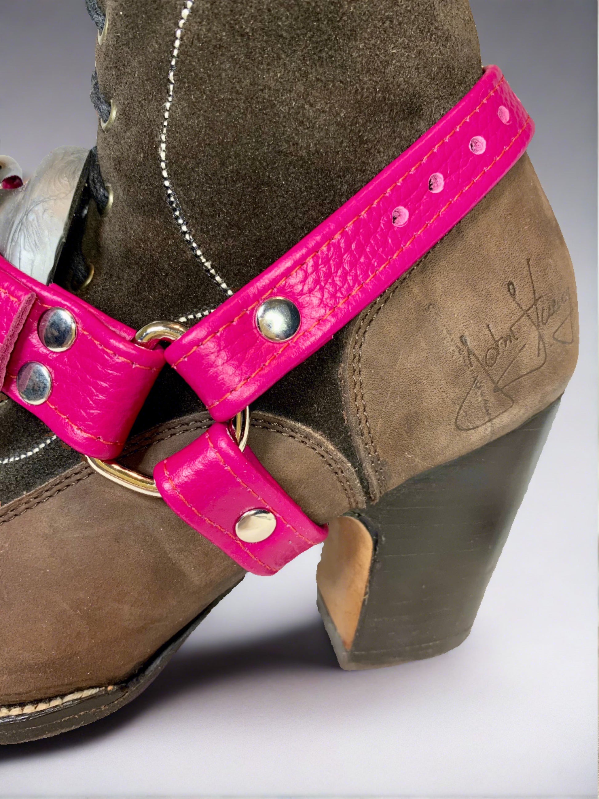 close up brown suede boot with magenta boot strapon
